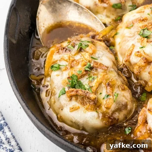 Closeup of a juicy pork chop covered in onions and provolone cheese.