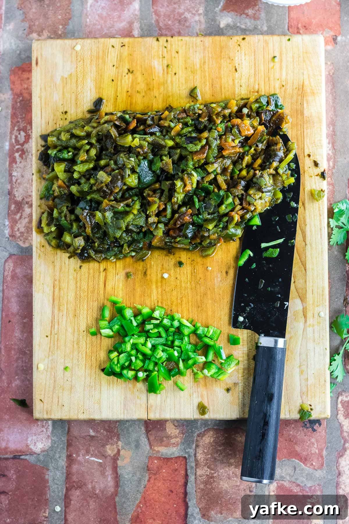 Slow Cooker Pork Chile Verde: Tender Pork in Tomatillo Sauce 4 Chopping the jalapenos and the roasted/peeled poblano peppers on a cutting board.