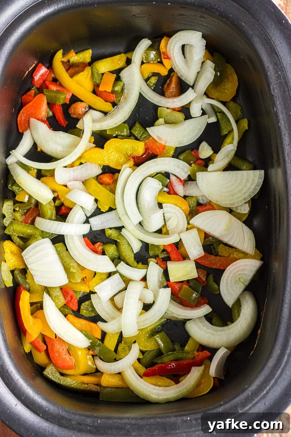Slow Cooker Pork Chile Verde: Tender Pork in Tomatillo Sauce 5 The frozen bell peppers and sliced onions in the slow cooker.