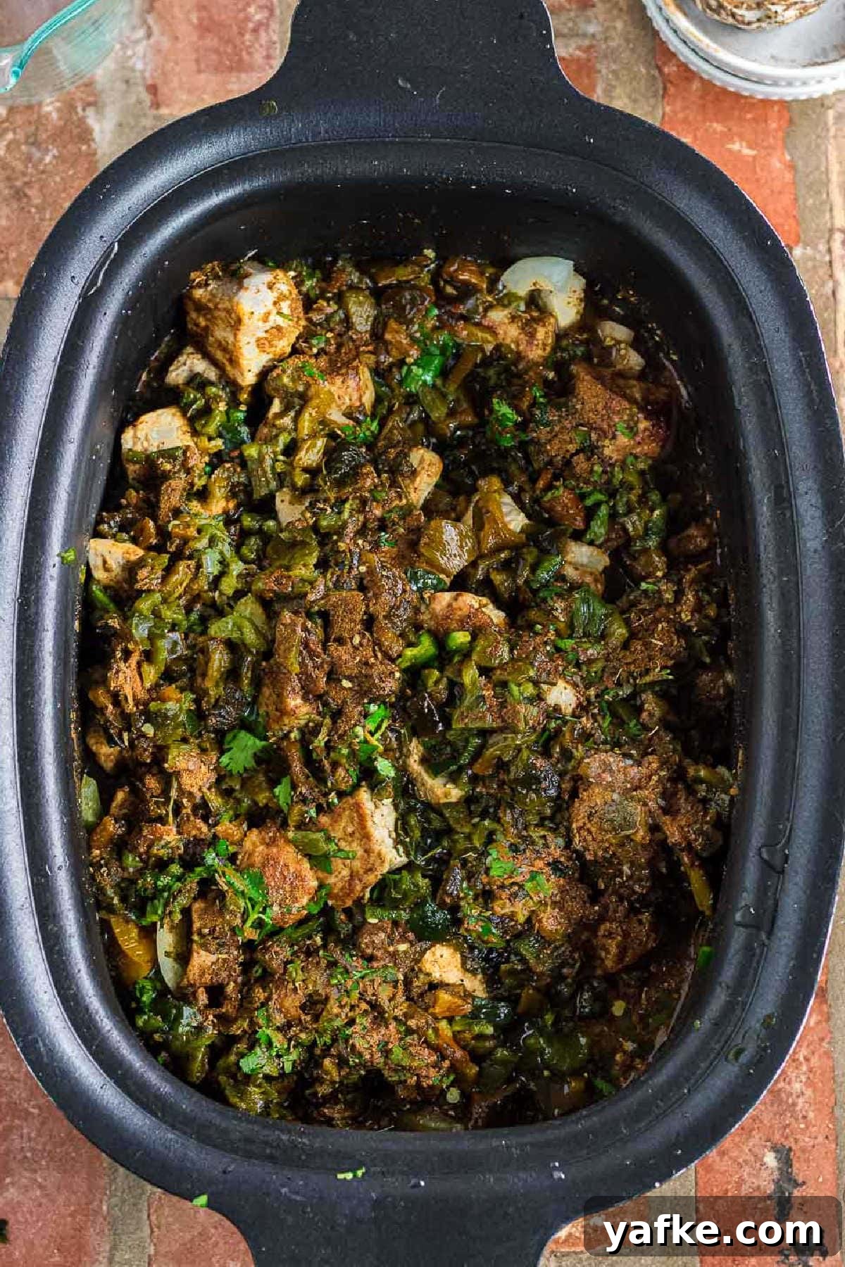 Slow Cooker Pork Chile Verde: Tender Pork in Tomatillo Sauce 7 The chopped peppers, seasoning, cilantro, and broth added to the slow cooker.