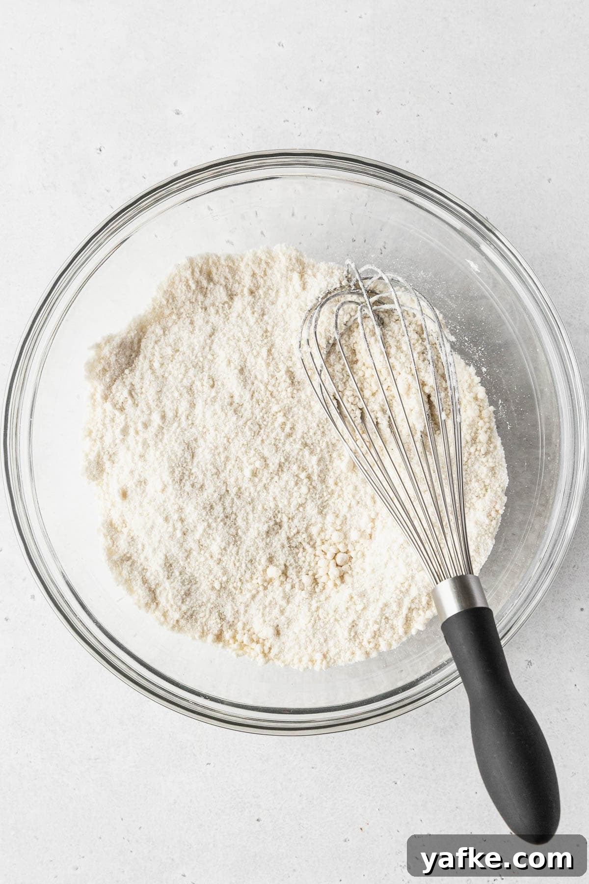 How to Make Dairy-Free Cupcakes 5 Dry ingredients whisked together in a clear glass mixing bowl.
