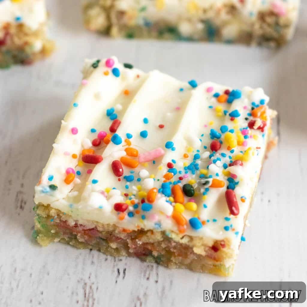 Birthday Cake Blondies Recipe with Sprinkles 2 birthday cake blondies recipe cut into bars and shown close up on white surface