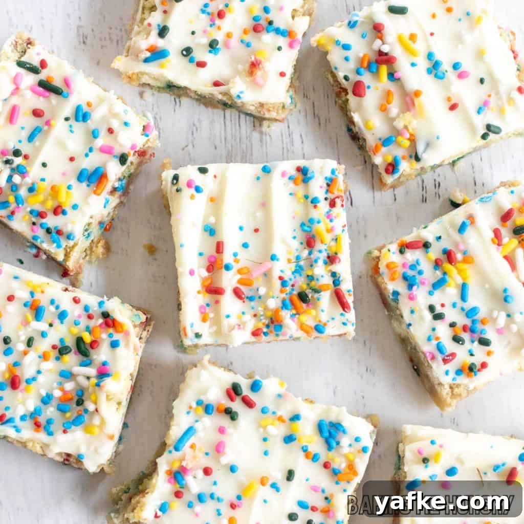 Birthday Cake Blondies Recipe with Sprinkles 12 birthday cake blondies spread out on white surface from overhead