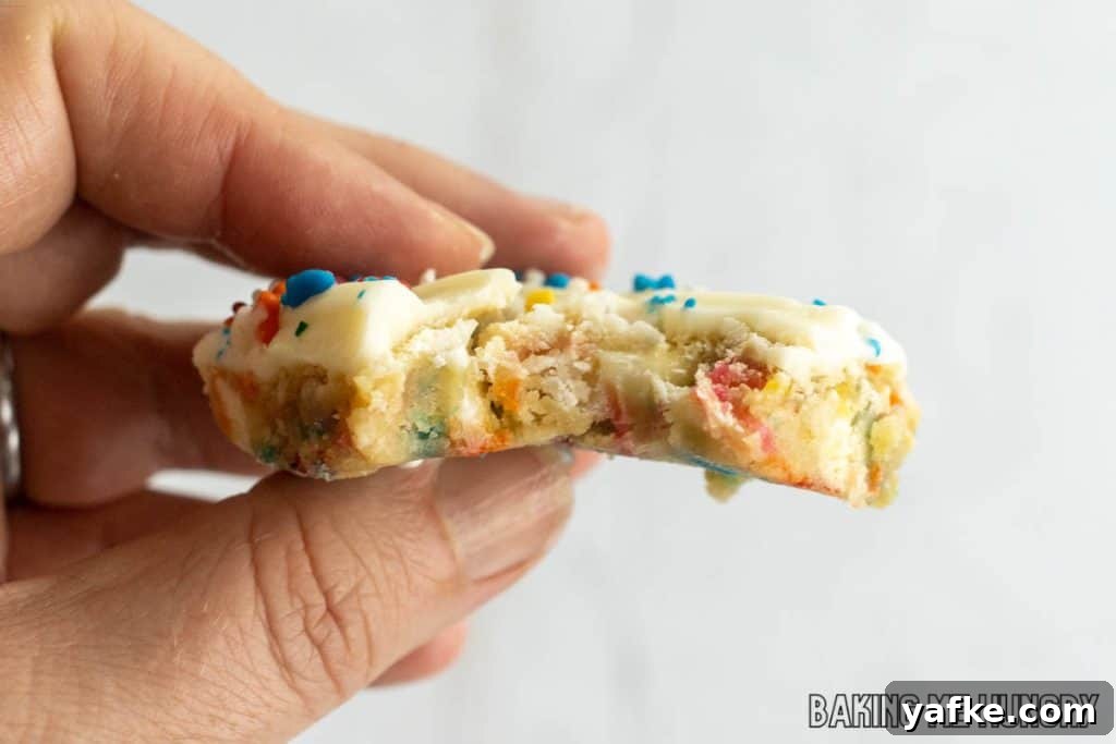 Birthday Cake Blondies Recipe with Sprinkles 13 hand holding one of the birthday cake blondies missing a bite