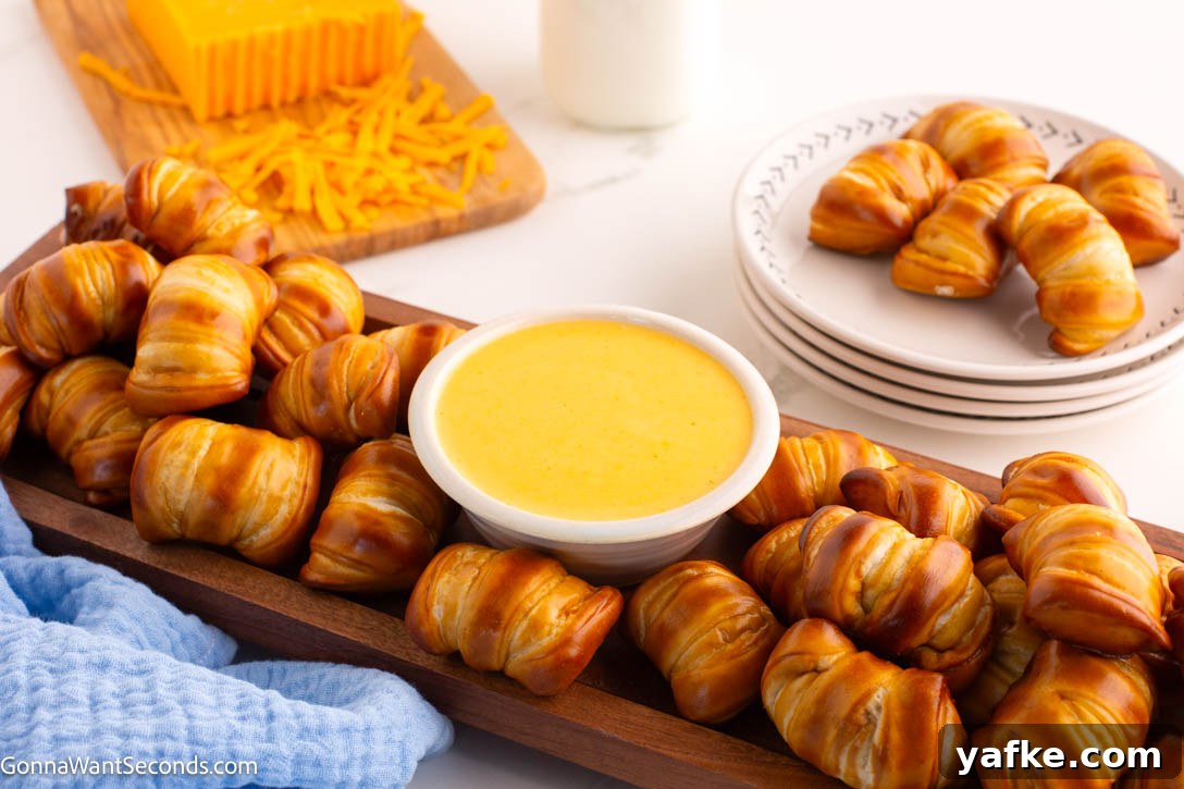 This creamy cheese sauce is a true kitchen staple. Pour it over broccoli, stir it on pasta for quick mac n' cheese, or serve it as a dip for pretzels and chips! #cheesysauce #cheesesauce creamy cheese sauce in a small bowl with pretzels around