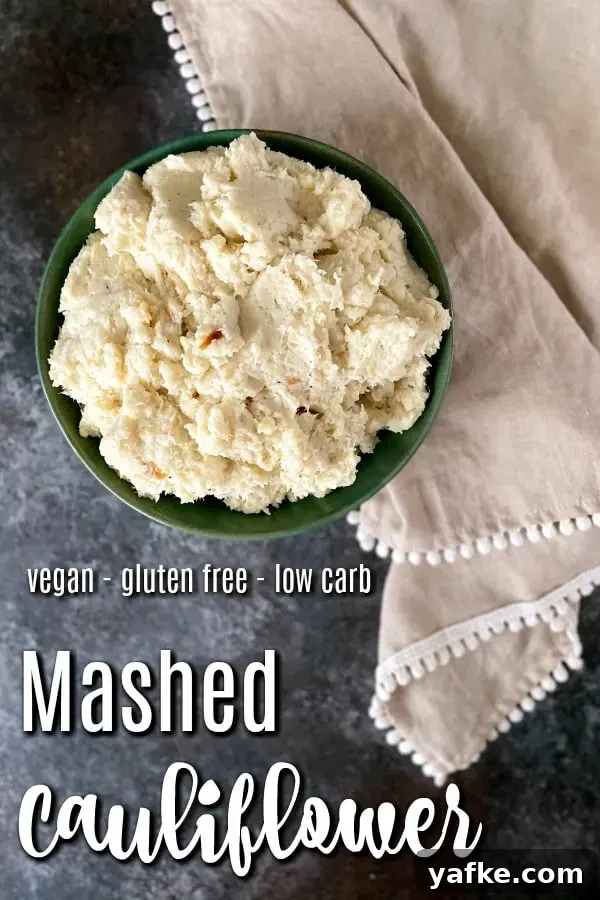 Mashed Cauliflower @spabettie #vegan #dairyfree #lowcarb #glutenfree #side overhead view of mashed cauliflower in a green serving bowl, beige napkin with white trim on side