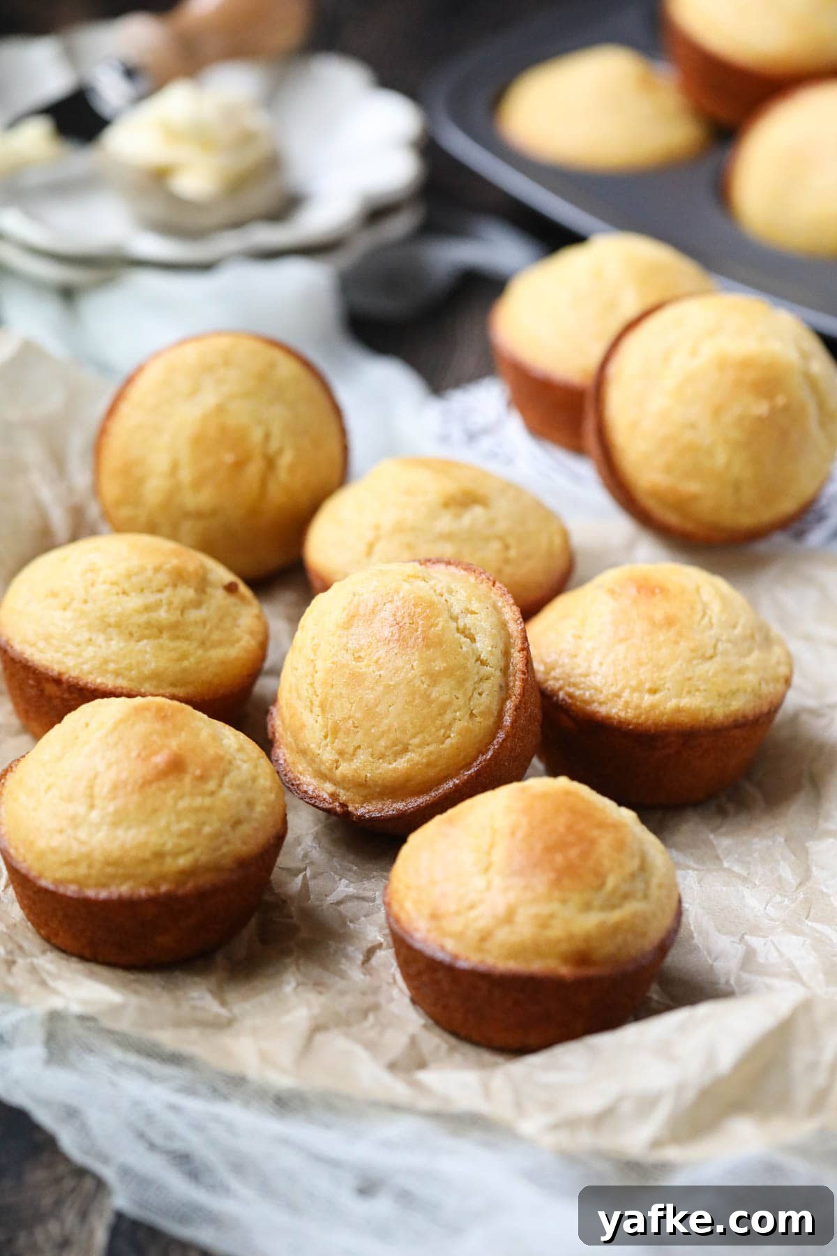 Moist Southern Sweet Cornbread Muffins Recipe 5 buttermilk cornbread muffins arranged on a wooden surface.