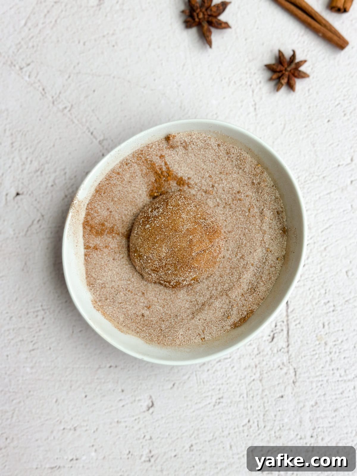 Chewy Brown Butter Pumpkin Snickerdoodles Recipe 9 cookie ball being rolled in sugar.