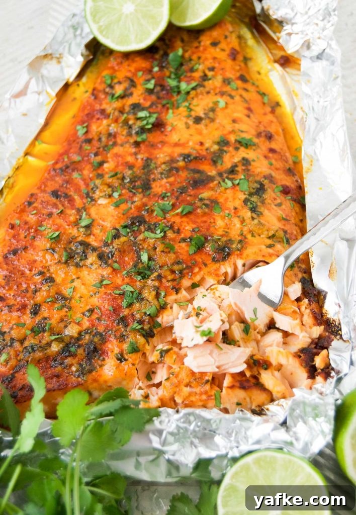 Zesty Oven-Baked Lime Salmon with Garlic and Herbs 7 Baked Lime Salmon on a baking sheet with cilantro and lime halves