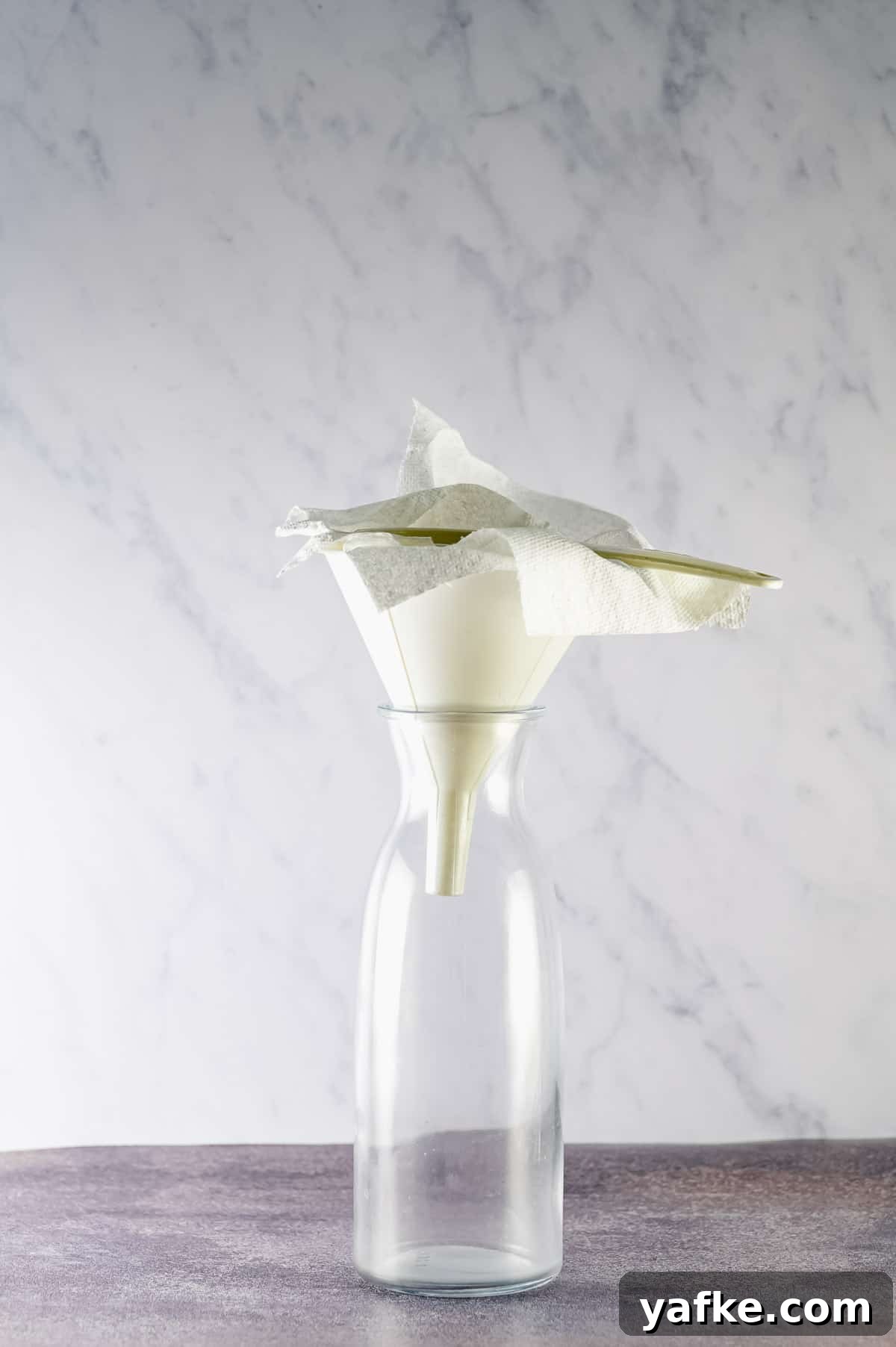 Cold Brew Coffee at Home: Smooth Concentrate in 12 Hours 2 A glass bottle with a paper towel lined funnel
