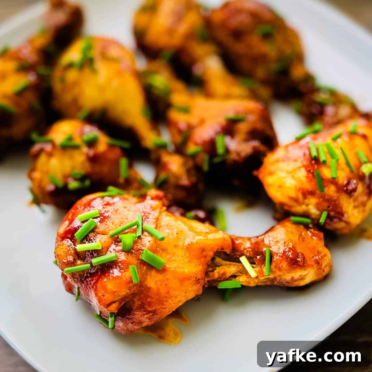 Juicy Instant Pot Chicken Drumsticks 5 A plate filled with BBQ chicken legs cooked in the Instant Pot.