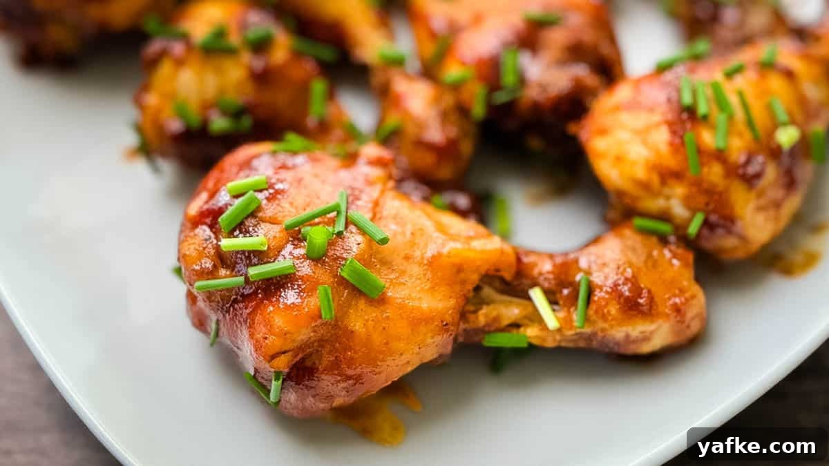 Juicy Instant Pot Chicken Drumsticks 6 Juicy BBQ chicken legs on a serving tray, garnished with chives.