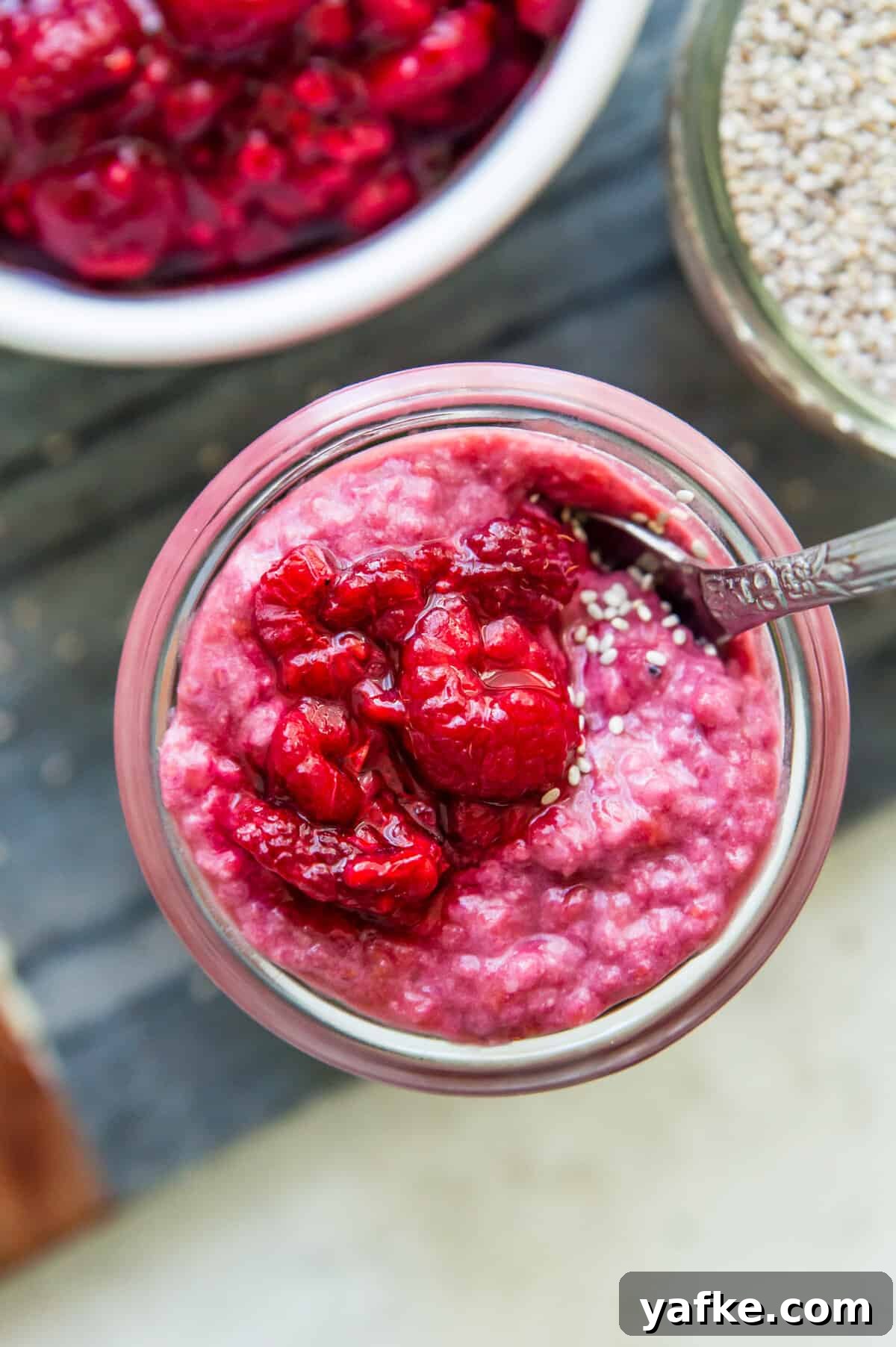 5-Ingredient Raspberry Chia Pudding Recipe 2 A jar of raspberry chia pudding topped with fresh raspberries and white chia seeds.