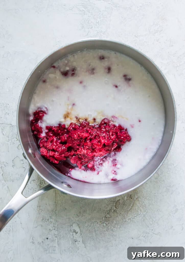 5-Ingredient Raspberry Chia Pudding Recipe 4 A pot with coconut milk and raspberries in it.