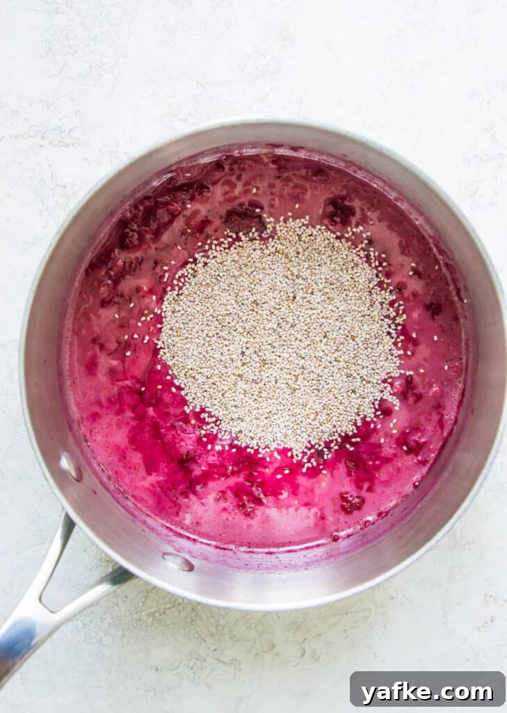 5-Ingredient Raspberry Chia Pudding Recipe 7 A pot with cooked raspberries in it with chia seeds on top.