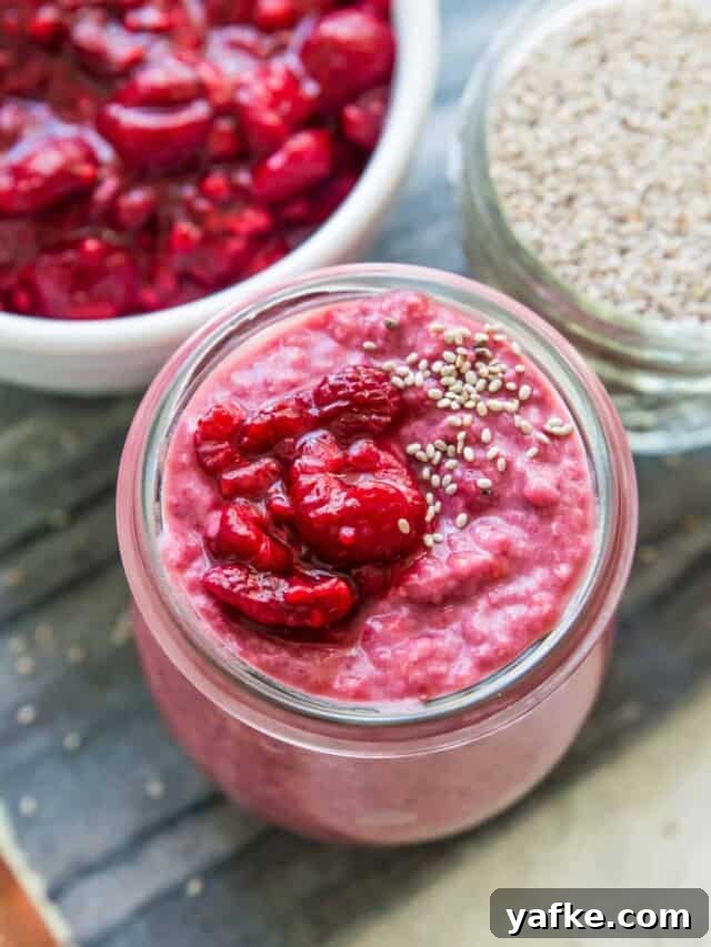 5-Ingredient Raspberry Chia Pudding Recipe 8 A glass jar with chia pudding in it with a few chia seeds sprinkled on top.