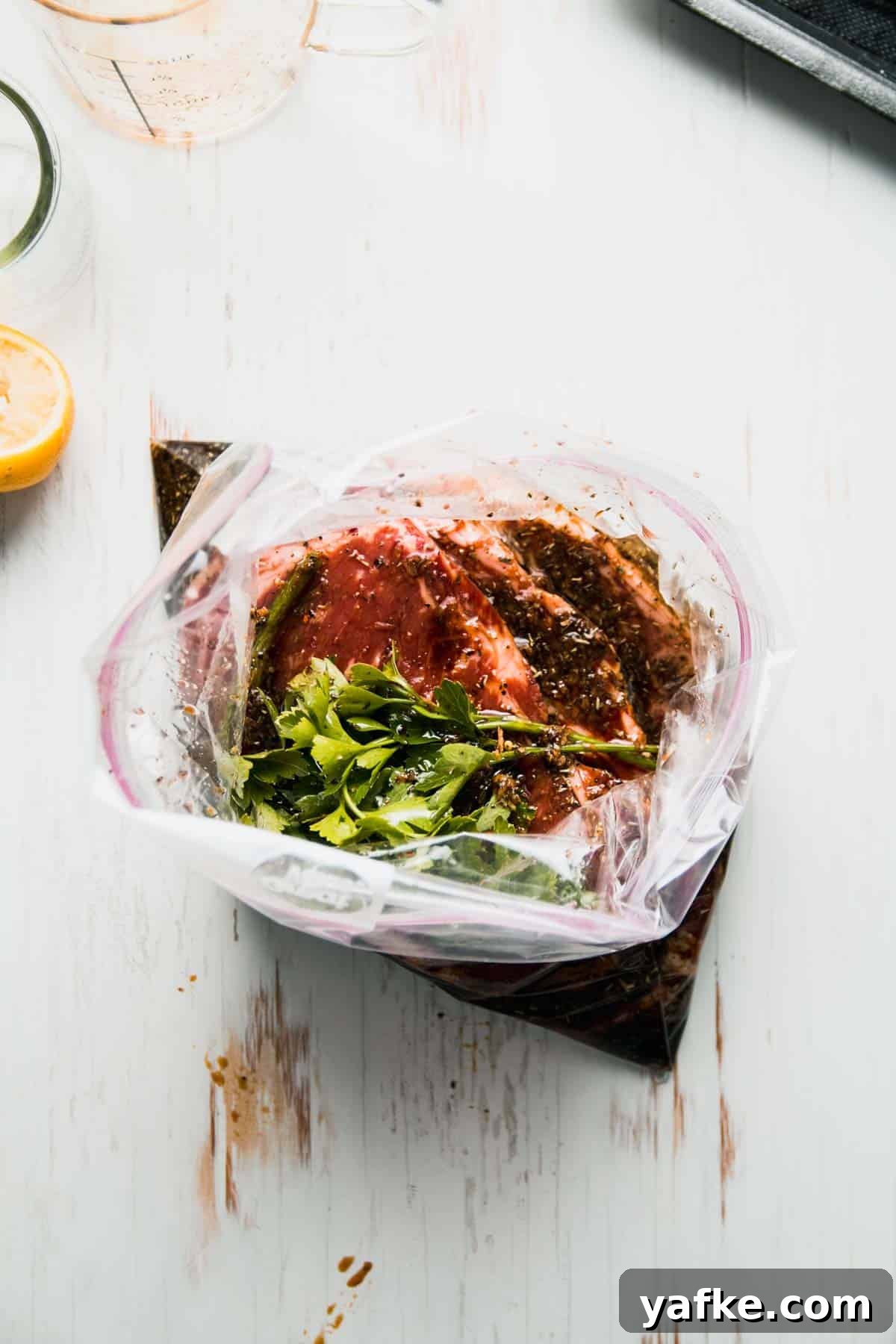 Gluten-Free Steak Marinade Recipe for Juicy Grilled Steak 5 Steaks in zip top bag with marinade and parsley on top.