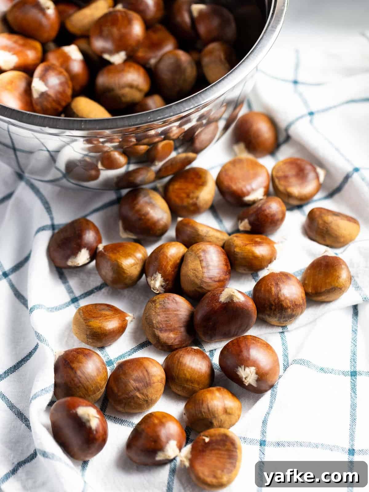 How to Make Quick Candied Chestnuts (Marrons Glacés) 4 Fresh chestnuts on a kitchen towel.