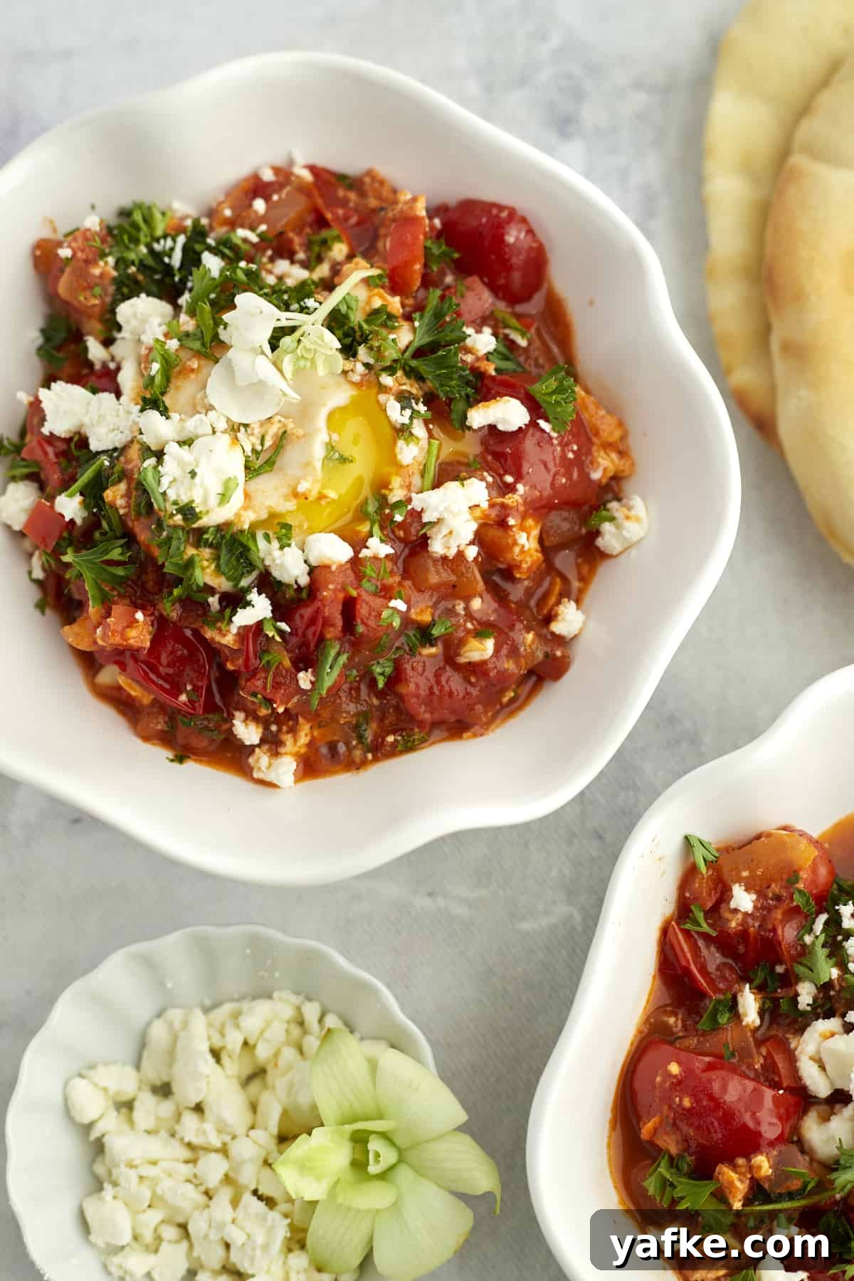 One-Pan Shakshuka with Feta and Fresh Herbs 10 two white bowls full of easy shakshuka with feta
