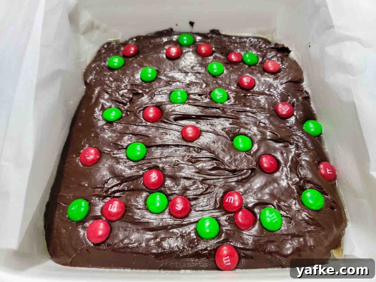 Decadent 4-Ingredient Chocolate Fudge 7 easy christmas fudge topped with red and green m&m's in an 8x8 inch baking dish.