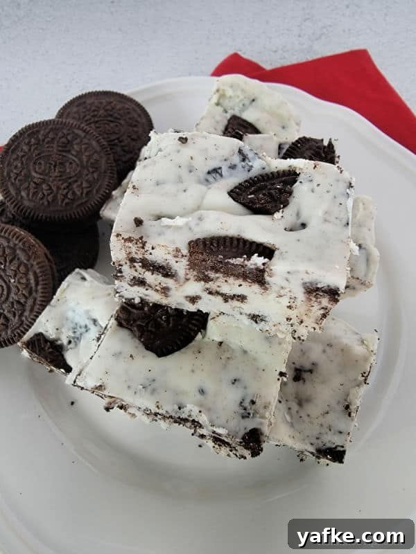 No-Bake 3-Ingredient Oreo Fudge Recipe 4 Oreo fudge squares on a white plate with Oreo cookies