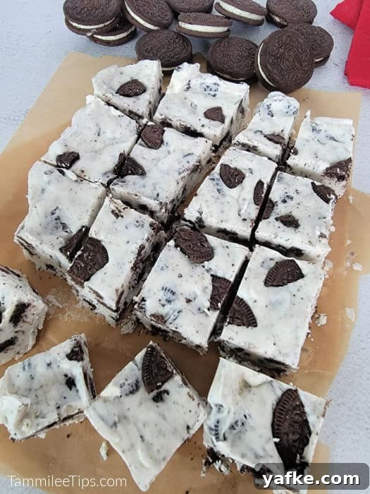 No-Bake 3-Ingredient Oreo Fudge Recipe 5 Oreo fudge on parchment paper cut into squares with Oreo cookies in the background