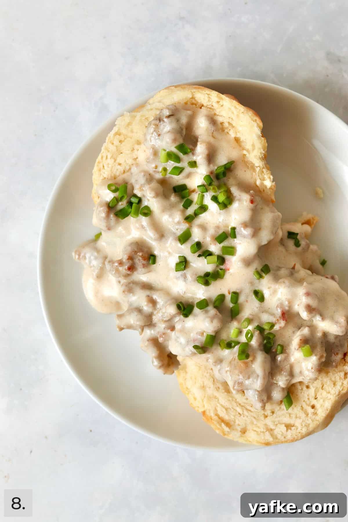 Single-Serve Biscuits and Sausage Gravy for One 11 One biscuit with sausage gravy on top on a small plate.