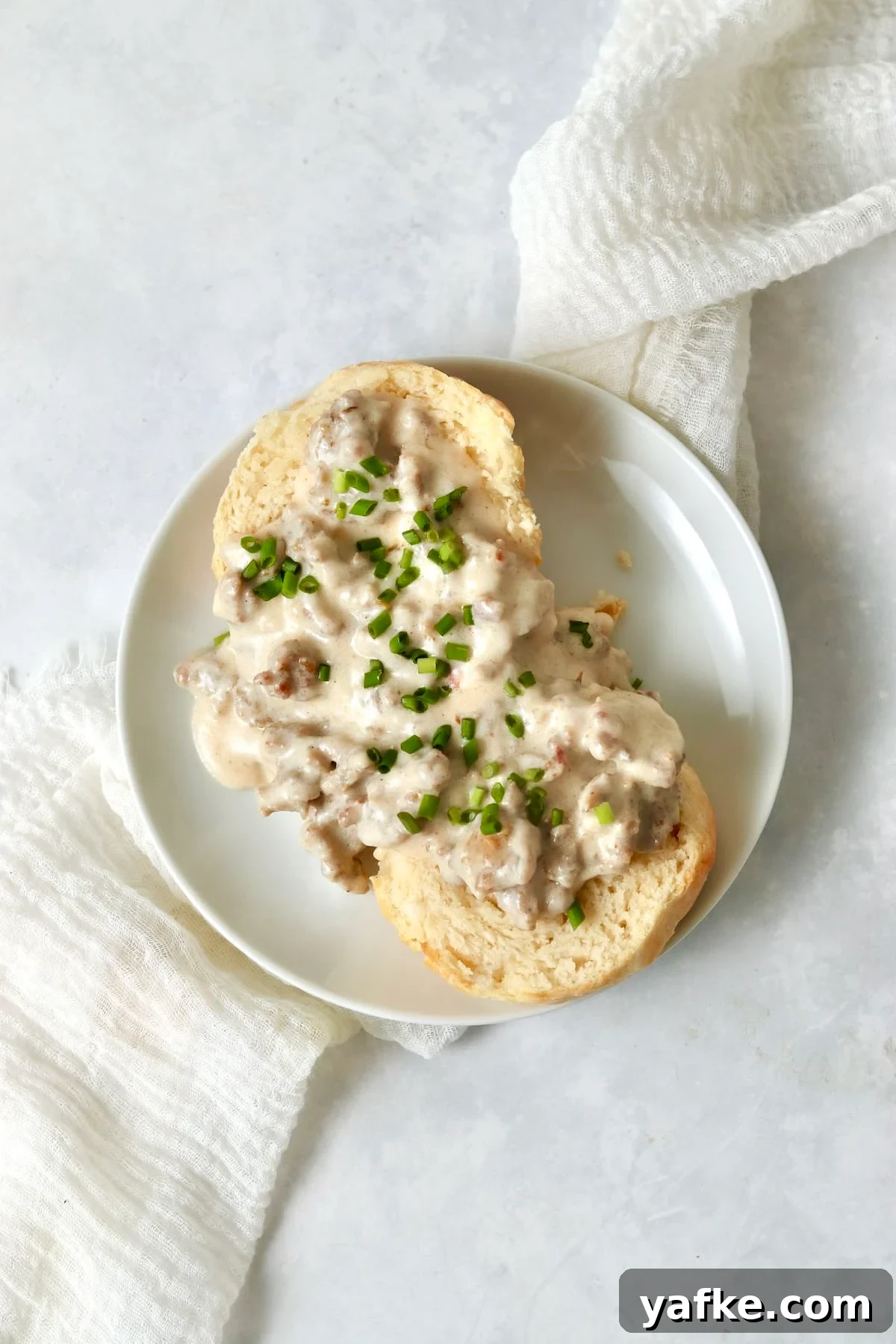 Single-Serve Biscuits and Sausage Gravy for One 12 Single serve biscuits and gravy with chives on a small plate.