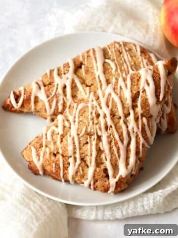Single serve apple cinnamon scones on a plate with a cinnamon icing drizzle.