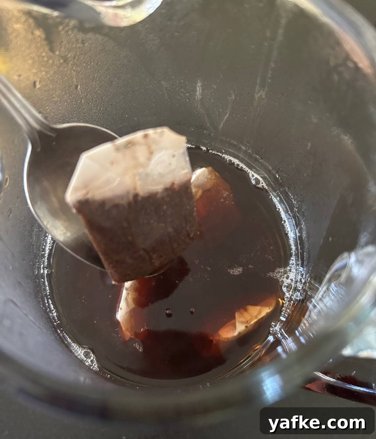 Removing tea bags from pitcher.