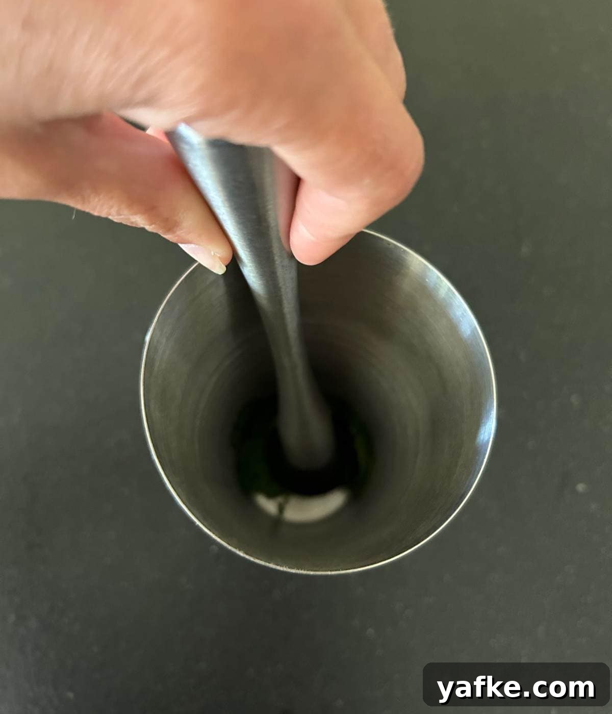Muddling mint in shaker cup.