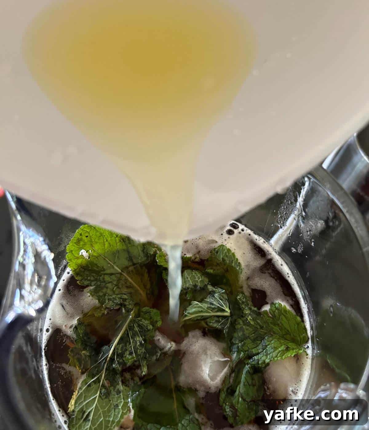 Pouring lemon juice into pitcher.