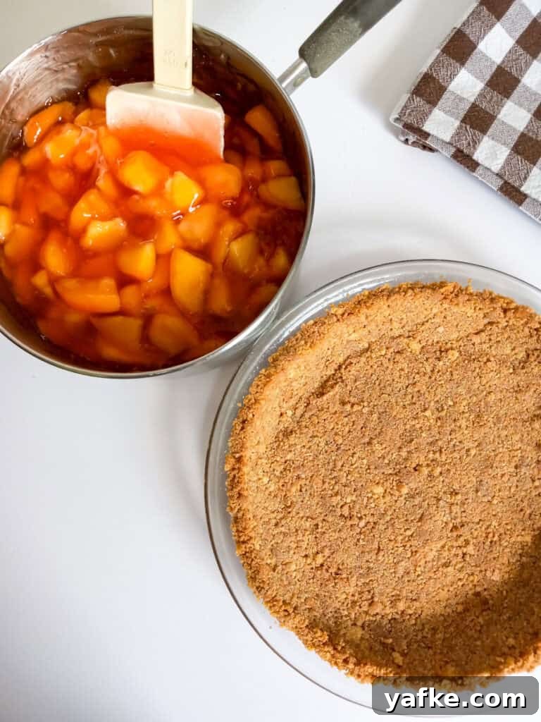 How to Make Authentic Amish Fresh Peach Pie 4 sliced peaches and sauce in saucepan beside a graham cracker crust.