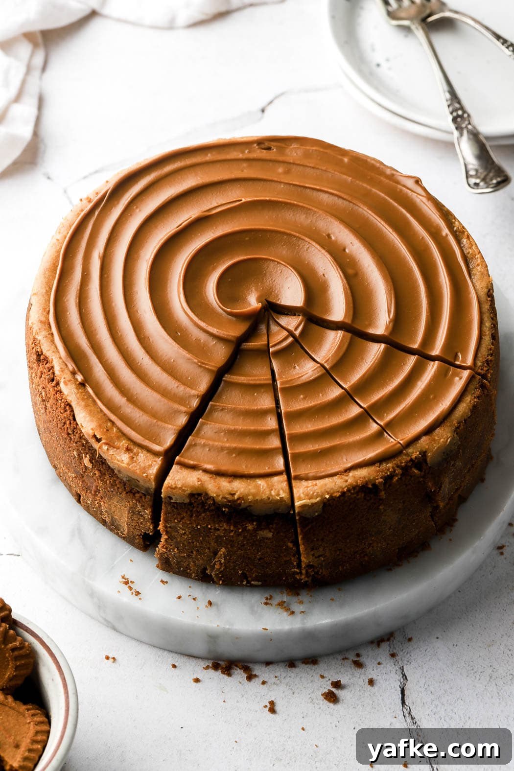 Creamy Lotus Biscoff Cheesecake Recipe 10 cheesecake with cookie butter swirl on top and three slices cut
