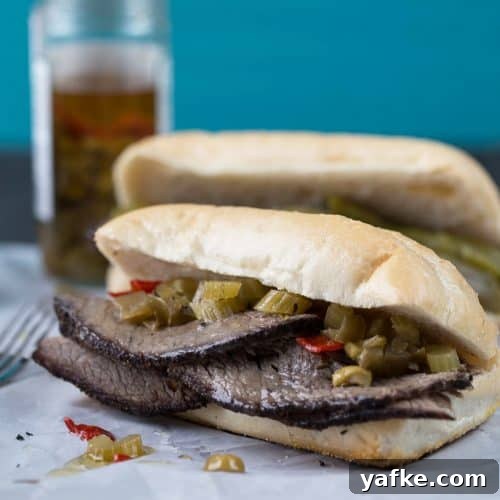 Classic Old Fashioned Sloppy Joes Sandwich Recipe 10 Italian beef sandwich on a soft roll, sitting on white parchment paper.