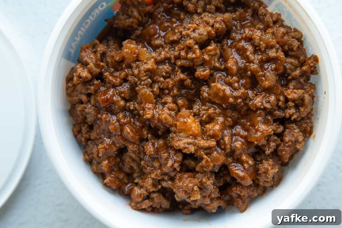 Classic Old Fashioned Sloppy Joes Sandwich Recipe 8 sloppy joe meat in a white plastic container next to a lid.