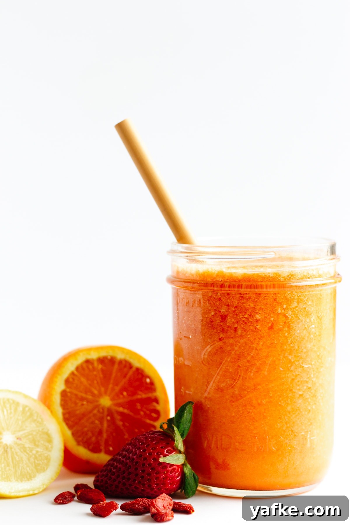 Vitamin C Boost Smoothie with Citrus and Berries 4 Smoothie in mason jar with bamboo straw with fruit sitting next to it.