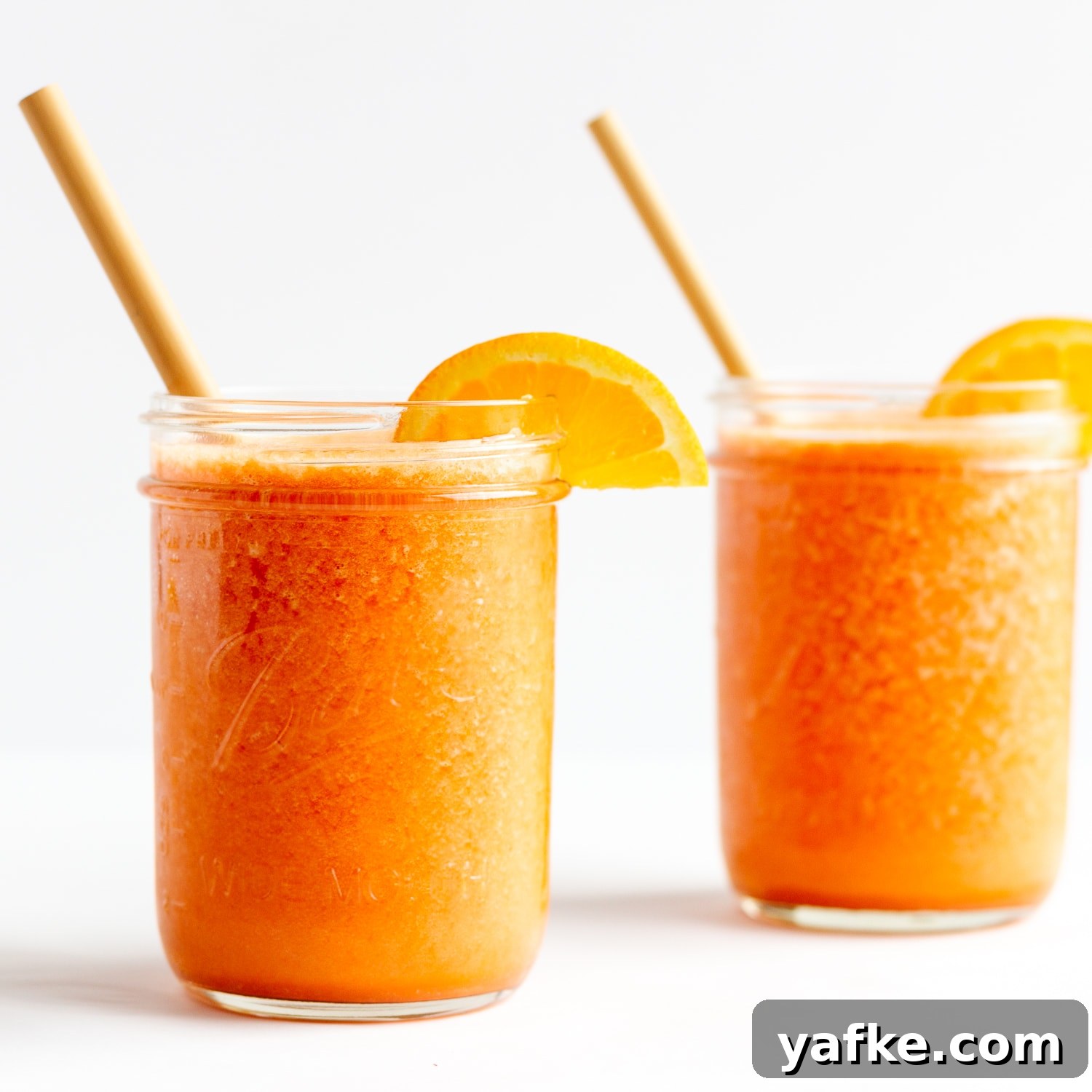 Vitamin C Boost Smoothie with Citrus and Berries 7 Two mason jars filled with Vitamin C Immune Boosting Smoothie and garnished with orange slices and a bamboo straw.