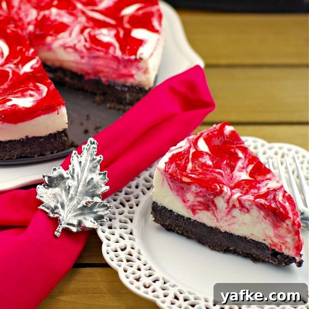 21 Patriotic Canada Day Desserts 2 a piece of strawberry rhubarb cheesecake on a white plate with a red napkin with Canadian flag napkin ring and remainder of cake in the background
