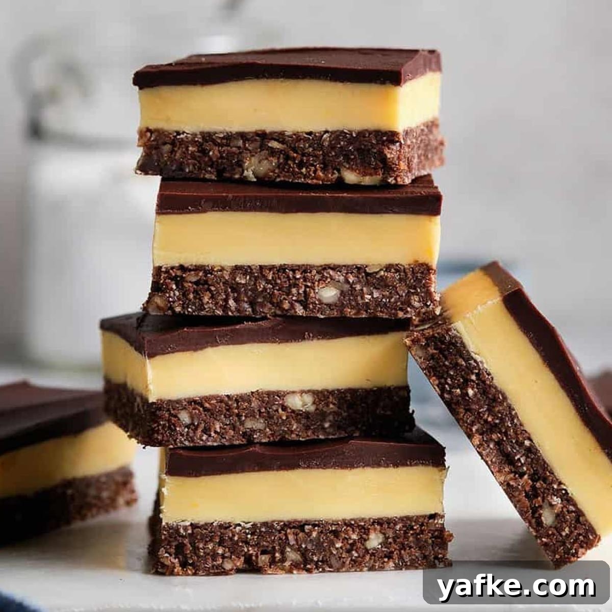 21 Patriotic Canada Day Desserts 19 5 Nanaimo bars piled up on a white plate, with one on each side