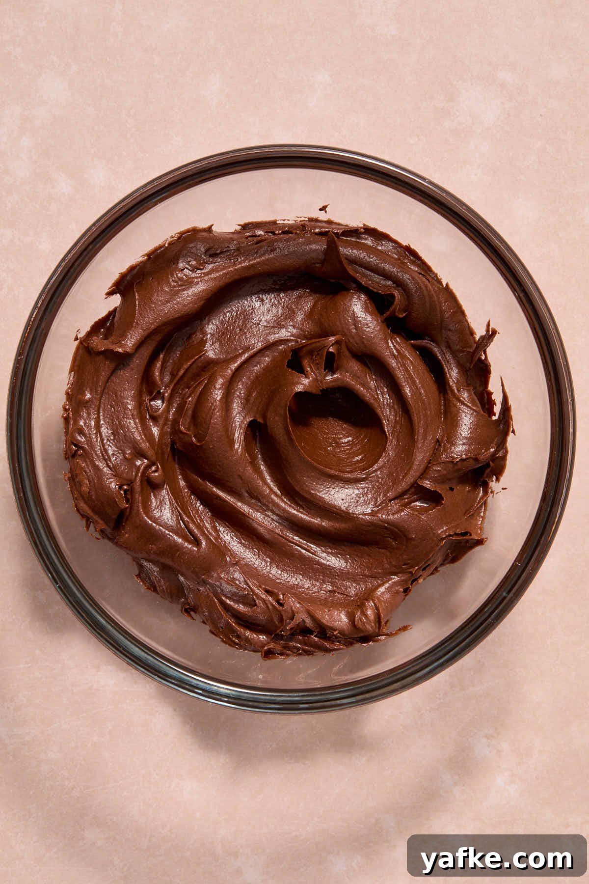 Almond Flour Cookie Cake with Peanut Butter and Chocolate Chips 12 Chocolate frosting in a glass bowl.