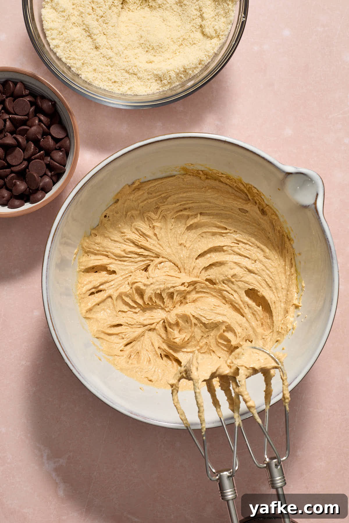 Almond Flour Cookie Cake with Peanut Butter and Chocolate Chips 7 All the wet ingredients mixed together in a bowl with the dry mixture and chocolate chips on the side.