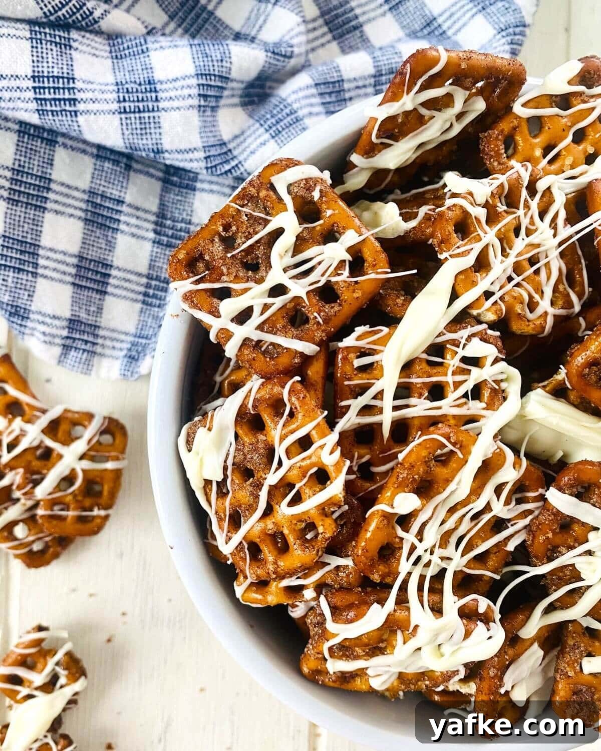 Pumpkin Spice Pretzels Drizzled with White Chocolate 2 pumpkin spiced pretzels with white chocolate drizzle.