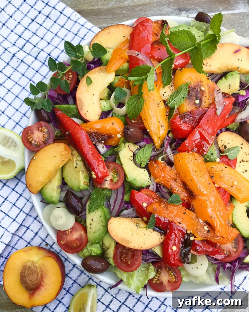 Fresh Mediterranean Avocado and Peach Salad with Peppers 3 close up view of a summery Mediterranean avocado and peach salad with roasted peppers, avocado, cherry tomatoes, hearts of palm, and more.
