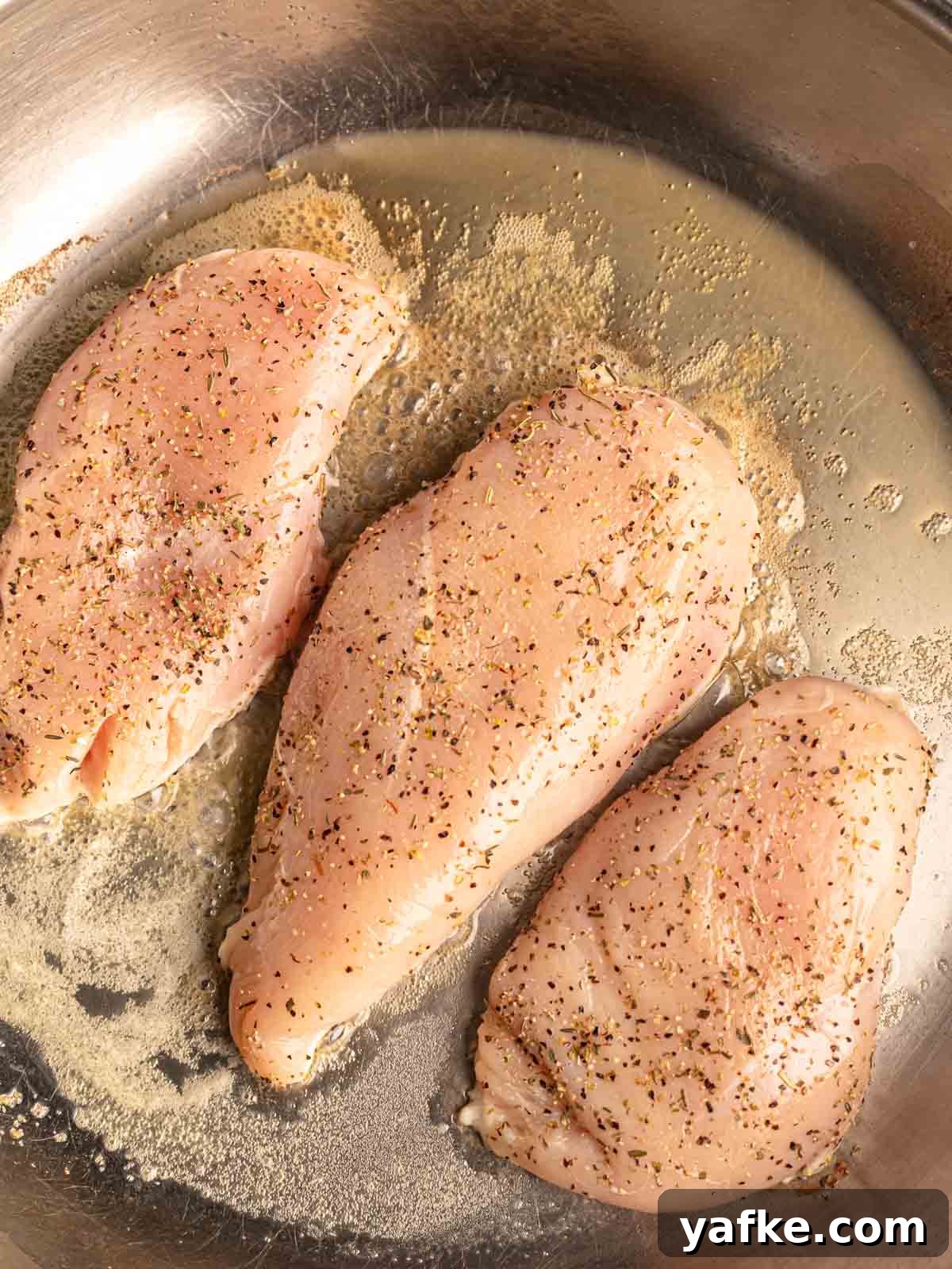 30-Minute Garlic Parmesan Chicken Pasta Recipe 4 Chicken breasts cooking in a skillet.