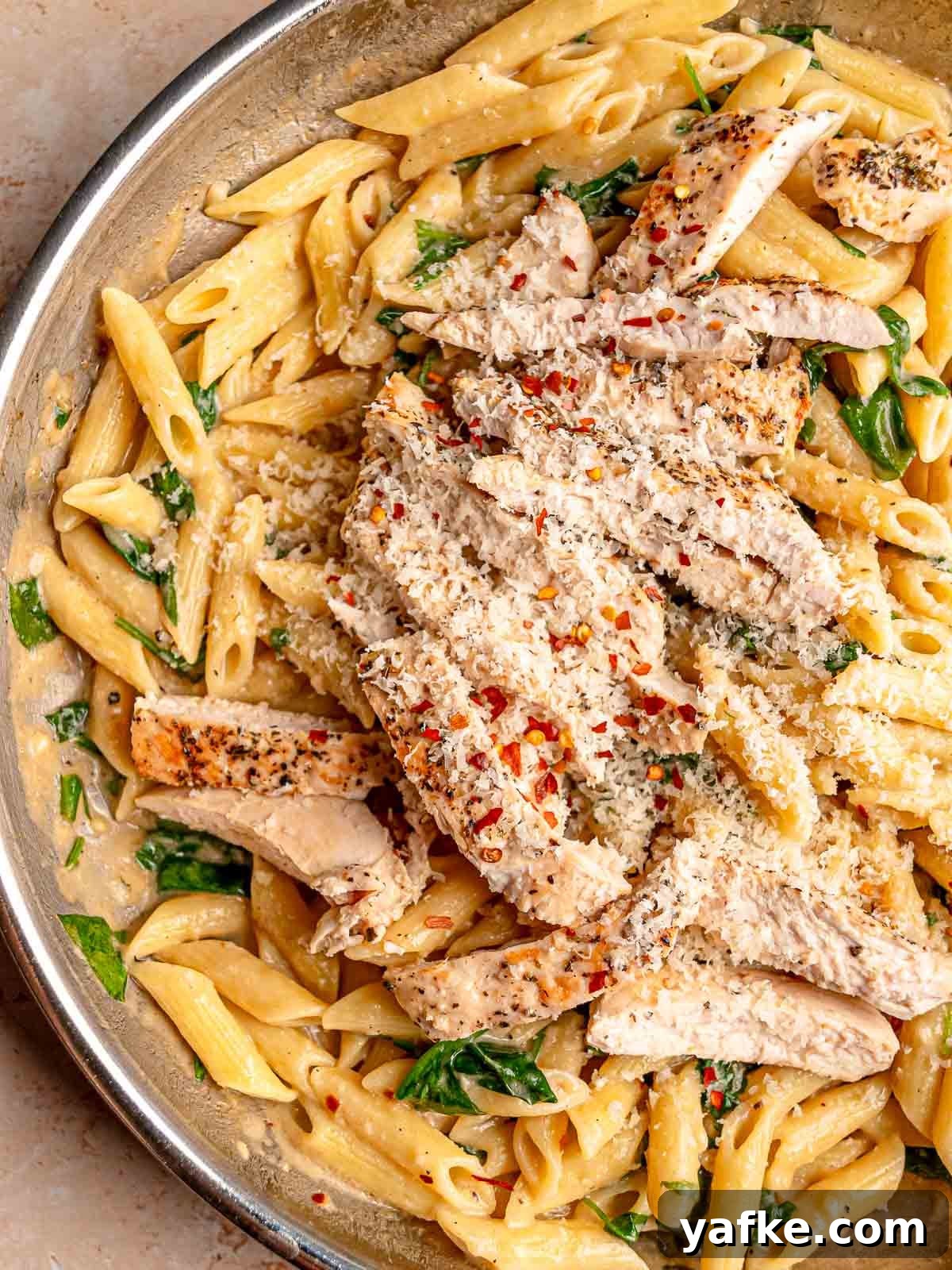 30-Minute Garlic Parmesan Chicken Pasta Recipe 7 Sliced seasoned chicken over creamy garlic Parmesan penne with spinach, red pepper flakes and freshly grated cheese.