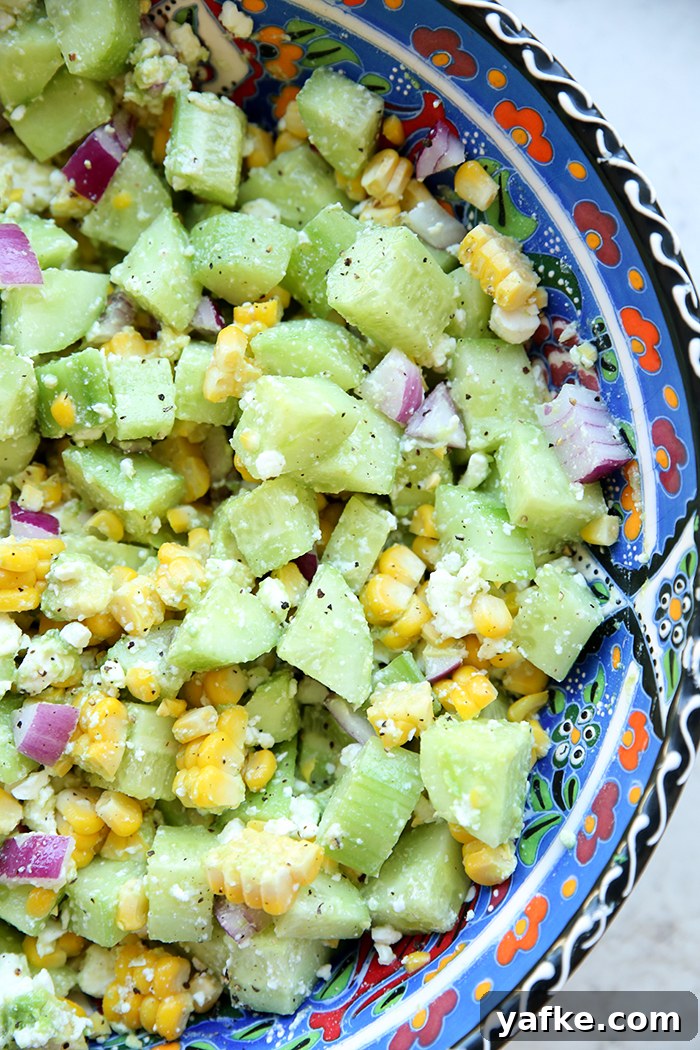 A large serving bowl filled with cucumber feta salad with lemon.