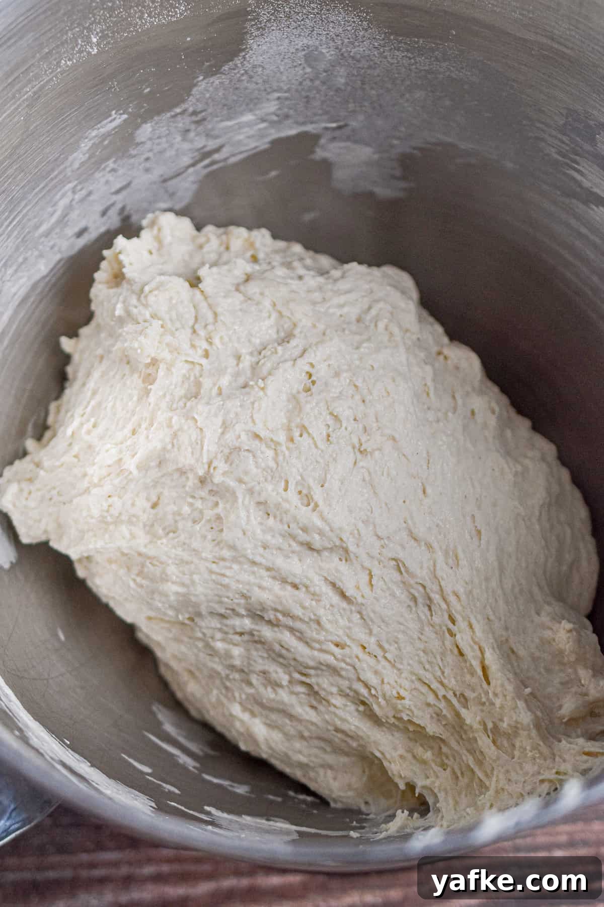 New York-Style Bagels Made with Sourdough Discard 6 The dough has risen in a metal bowl.