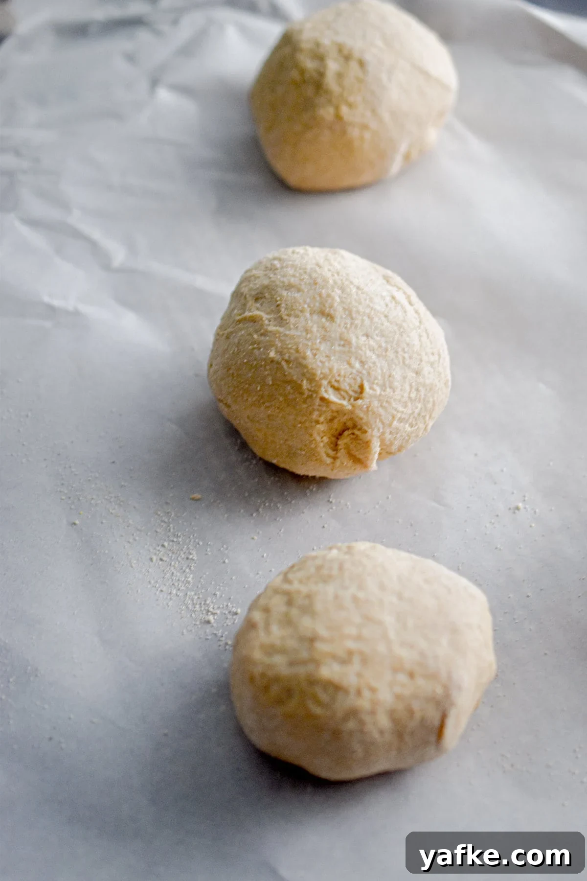 New York-Style Bagels Made with Sourdough Discard 7 A ball of dough is on a parchment lined baking sheet.