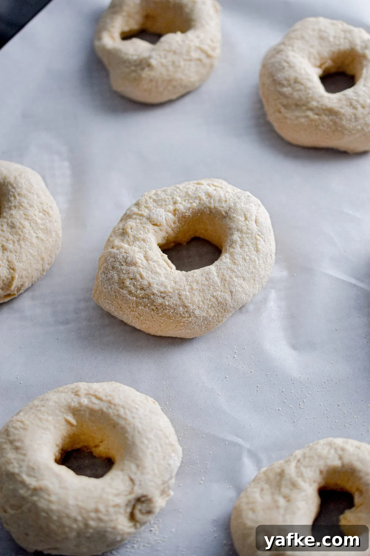 New York-Style Bagels Made with Sourdough Discard 8 The shaped bagel is on a parchment lined baking sheet.